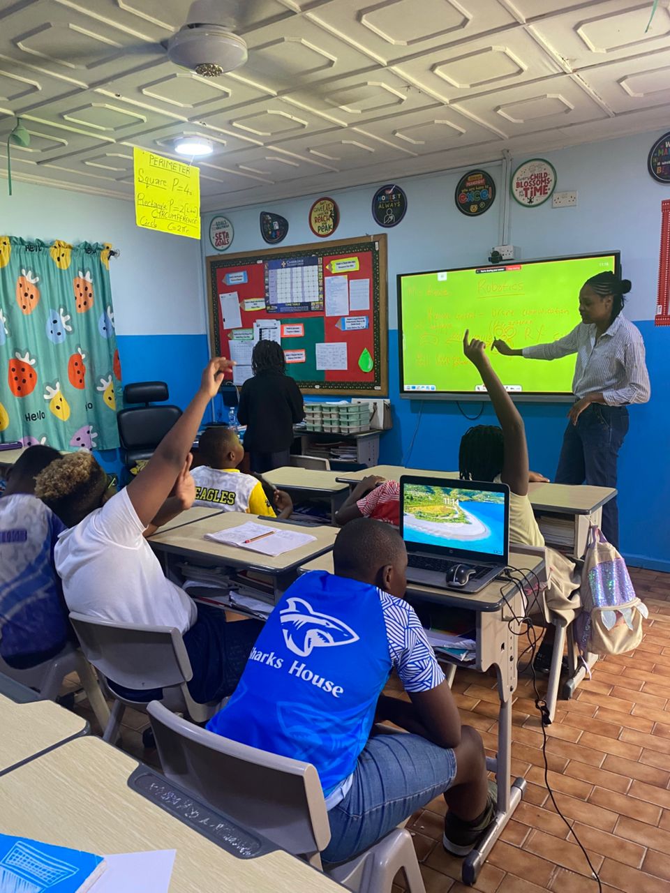 Students raising hands during a robotics lesson